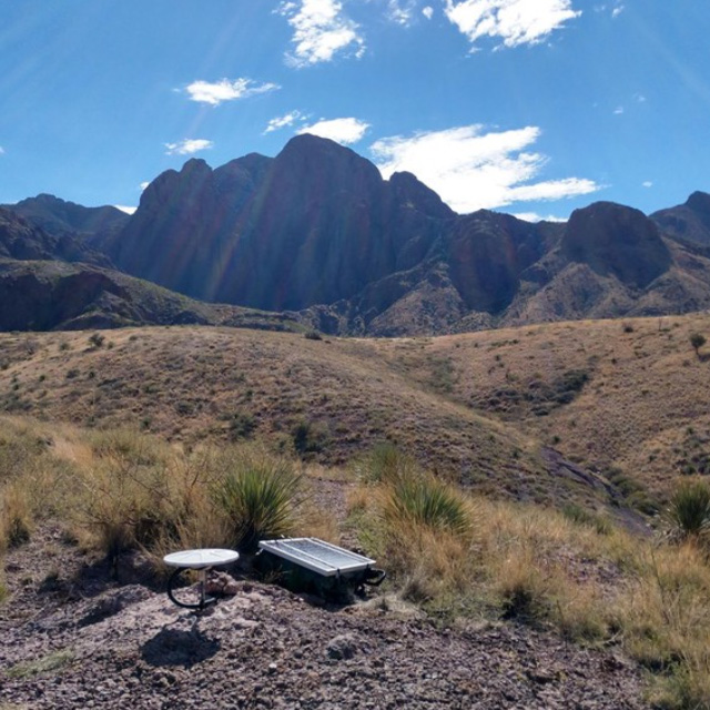 Hydrology sensor in the ground with mountains in the background