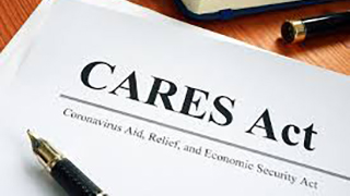 Image of pen and piece of paper that says "CARES Act"