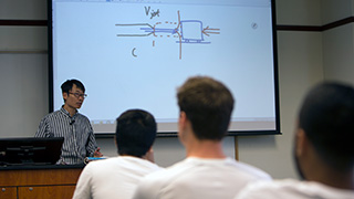 Image of a professor at a whiteboard.