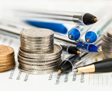 Closeup image of different types of money and pens