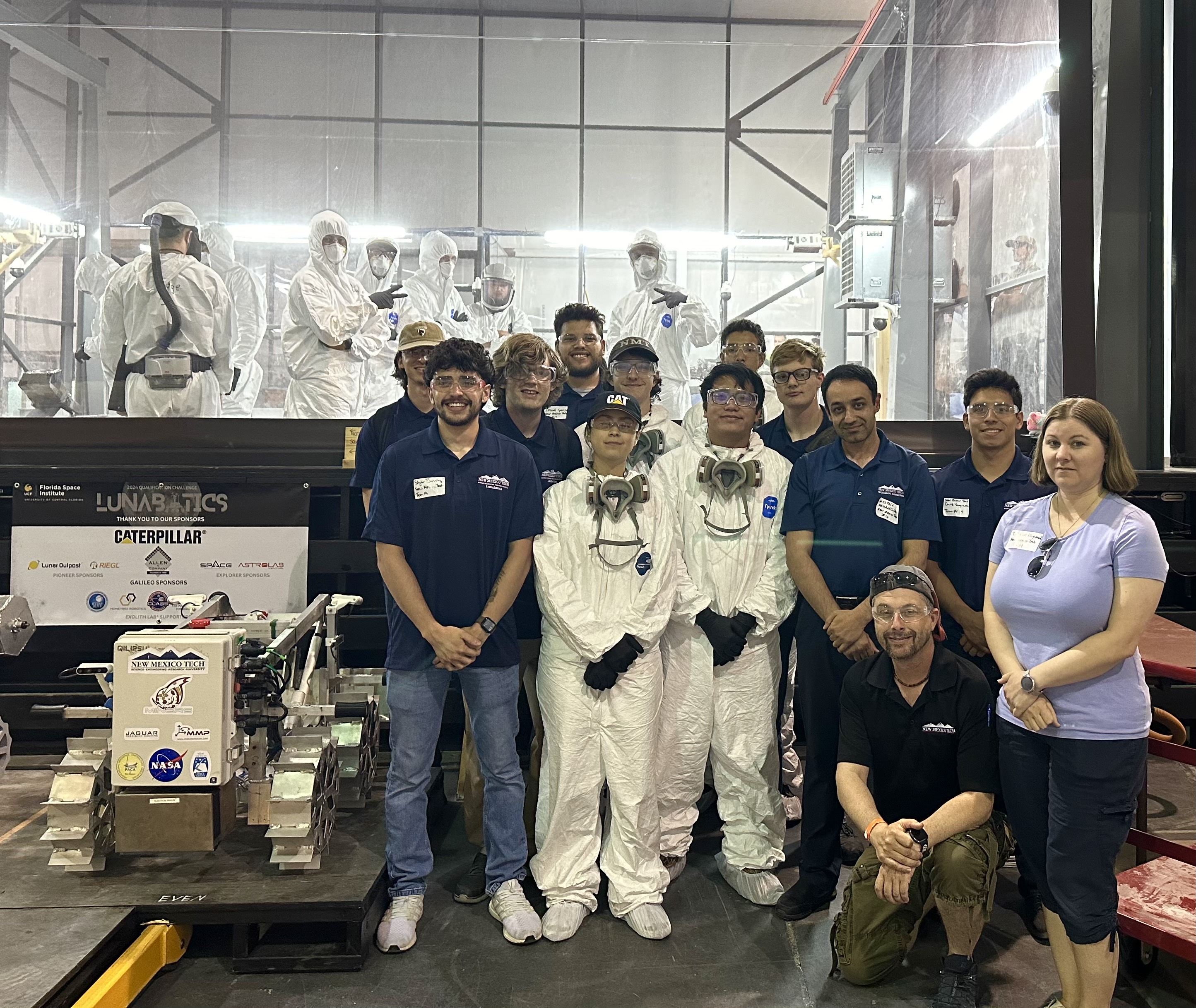 The NMT Team and lunar robot before one of the challenge runs. Robot operators in the pit wear protective clothing and respiratory gear as the simulated moon dust is irritating to skin and lungs.
