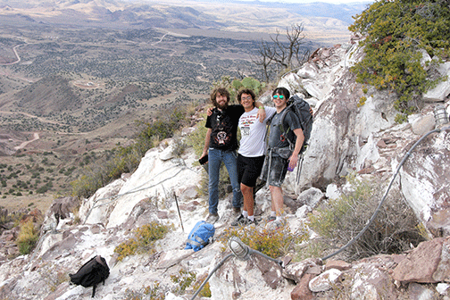 Three students posing atop M Mountain